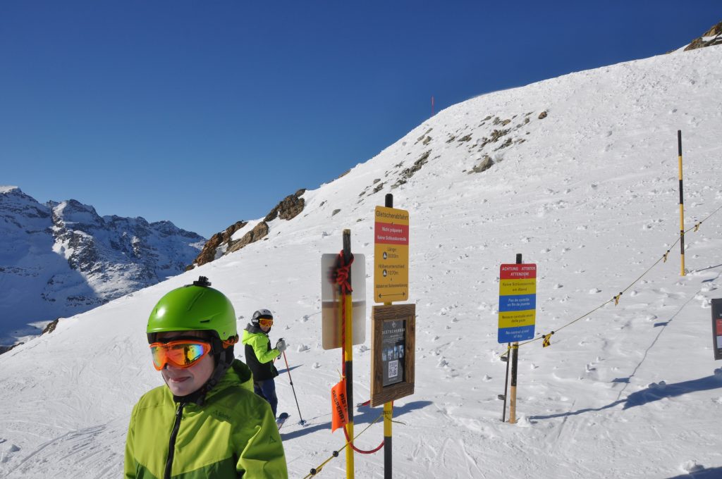 Zwei Kinder in Skiausrüstung am Beginn der Gletscher-Ski-Abfahrt von der Diavolezza über den Morteratsch-Gletscher.