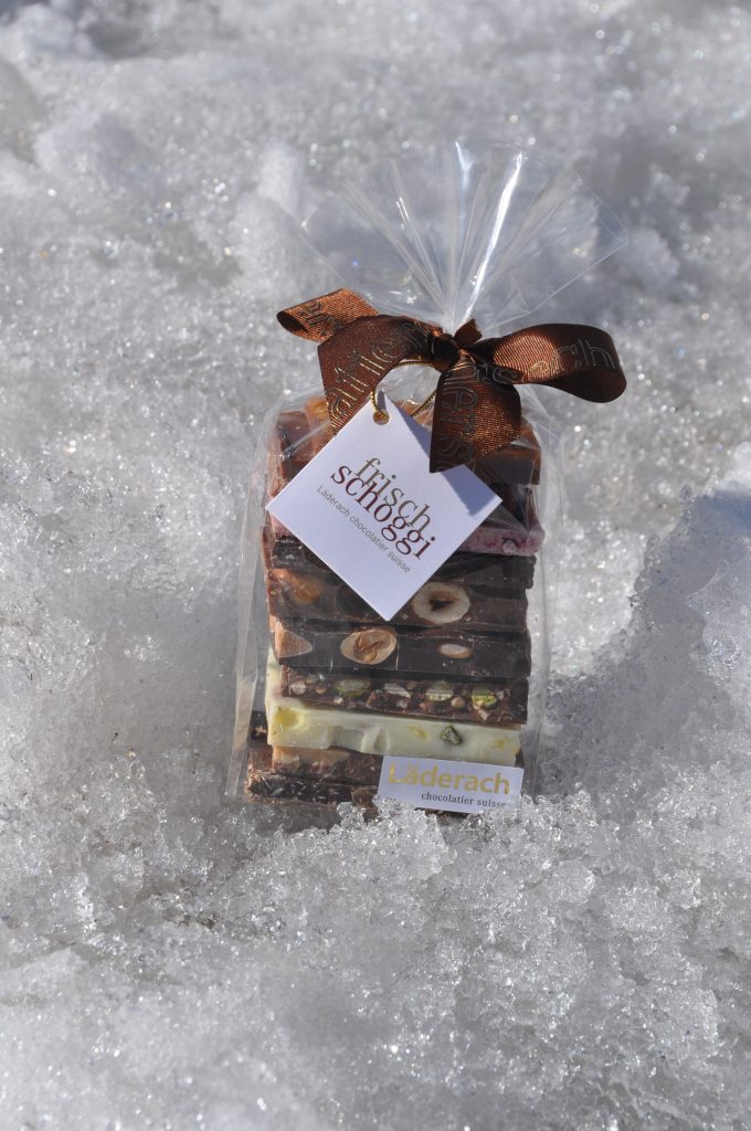 Probierpackung Läderach-Schokolade im Schnee.