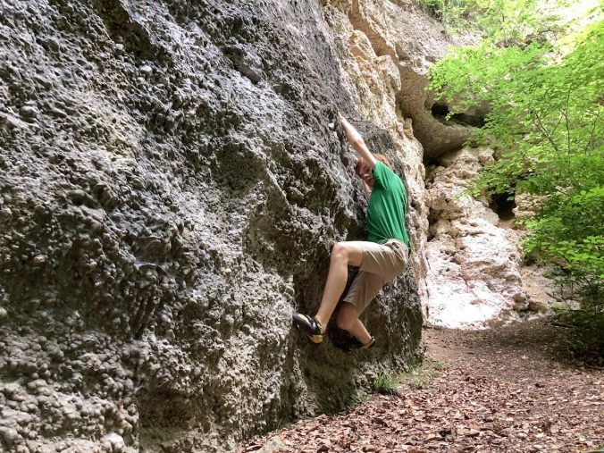 Bouldern in Buchenhain. Junge in grünem T-Shirt bouldert in einem Quergang