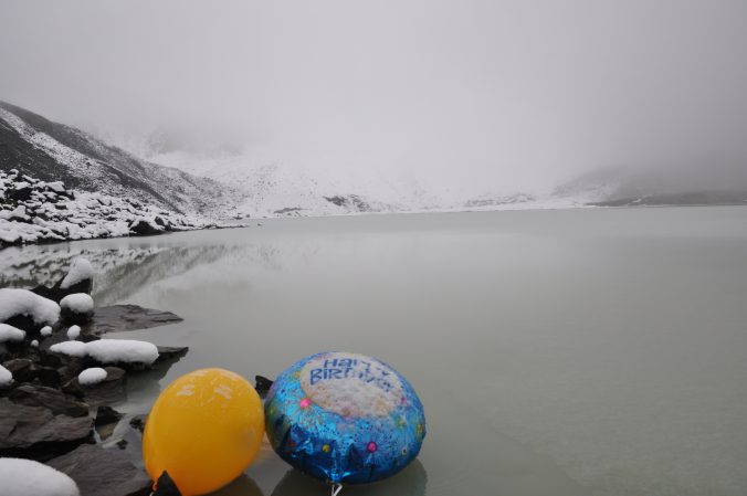 Zwei bunte Luftballons, in eisiger, nebliger Seenlandschaft